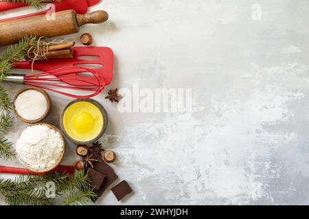 Weihnachtsbackhintergrund mit Tannenbaum aus Küchenutensilien, Tannenzweigen und Backzutaten. Stockfoto