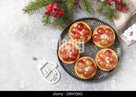 Vorspeisen zu Weihnachten. Tartlets mit Huhn und Trauben auf dem festlichen Tisch. Blick von oben. Kopierbereich. Stockfoto