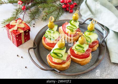 Kreative Vorspeisen weihnachten. Weihnachtsbaumkanapees mit Salami, Käse, Oliven, Tomaten und Gurken auf einem Baguette. Spac kopieren Stockfoto
