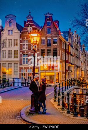 Amsterdamer Kanäle am Abend, ein Paar Männer und Frauen auf einem Stadtausflug in Amsterdam Stockfoto