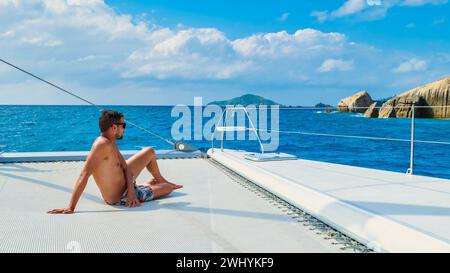 Junge Männer auf einer Fahrt mit dem Segelboot auf den tropischen Seychellen Stockfoto