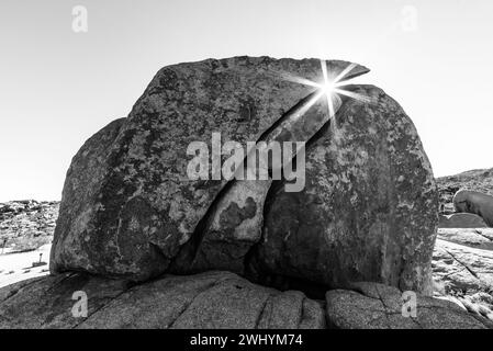 Joshua Tree National Park, Sonnenschein, gerissener Felsblock, Linsenflare, Sonnenspitzen, Wüstenlandschaft, Sonnenlicht durch Felsen Stockfoto