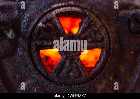 Radioaktives Symbol, Gusseisen, Hintergrundbeleuchtung, glühende Kohle, Flamme, Warnschild, Gefahr, nukleare Gefahr, Strahlungssymbol Stockfoto