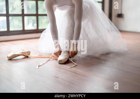 Ballerina in Ballettschuhen. Asiatische girlÂ Bänder von Zehenschuhen. Balletttänzerin, die Ballettschuhe in Dance stu trägt Stockfoto