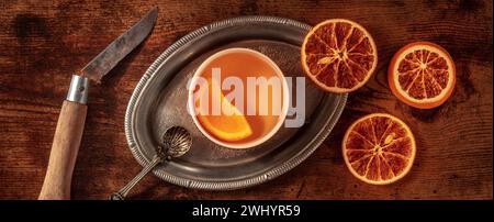 Orangentee mit frischen und getrockneten Orangen Panorama, auf einem Vintage-Tablett Stockfoto