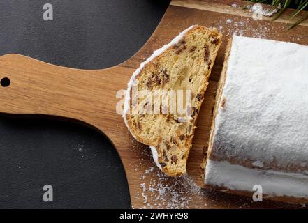 Weihnachtsgebäck Stollen bestreut mit Puderzucker auf dem Tisch, festliches Dessert Stockfoto