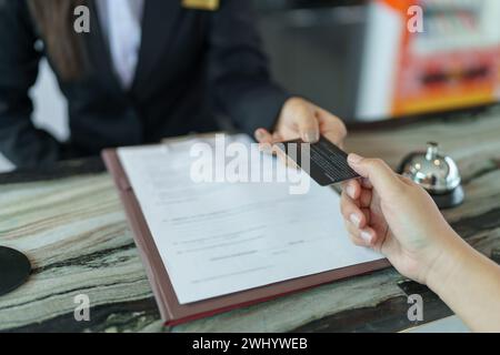 Hotelrezeptionist in Uniformen, Concierge gibt den Schlüssel und macht ihn Stockfoto