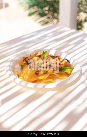 Ein Teller mit Muscheln und Pommes Frites an einem italienischen Strand Stockfoto