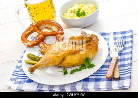 Halb gebratenes Huhn, Bier, Brezel und Kartoffel Stockfoto