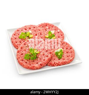 Vier rohe Hamburger-Scheiben auf weißer Platte Stockfoto