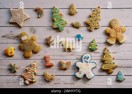 Weihnachtskekse mit farbenfroher Glasur liegen auf einem hellen Holztisch Stockfoto