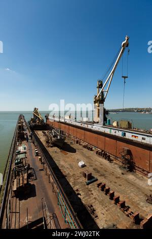 Großes Schwimmdock, Schiffsreparaturstation mit Kran an sonnigen Tagen. Leeres Trockendock, Infrastruktur der Seeindustrie. Wartung des Seeschiffes Stockfoto