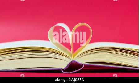 Buch in Herzform. Seiten eines Buches, die sich zu einer Herzform geformt haben. Geöffnetes Buch, Seiten in Herzform Stockfoto