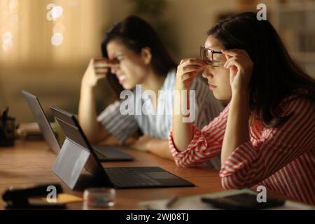 Müde freiberufliche Arbeiter beschweren sich, nachts zu Hause zu arbeiten Stockfoto