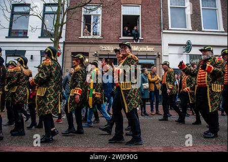 Nijmegen, Niederlande. Februar 2024. Man sieht Menschen, die traditionelle Karnevalskostüme aus der regio tragen. In Nijmegen, Niederlande, besteht die Karnevalsparade aus einem Wagen, der von einem Elektrofahrzeug mit den Prinzen und Prinzessinnen des Jahres gezogen wird. Der Rest der Parade besteht aus Personen, die in bunten Kostümen und Musikbands gekleidet sind. Die Hauptattraktion jedes Jahr ist das Kostüm, das der Bürgermeister der Stadt Huber Bruls trägt, dieses Jahr war das Thema Flower Power. Quelle: SOPA Images Limited/Alamy Live News Stockfoto