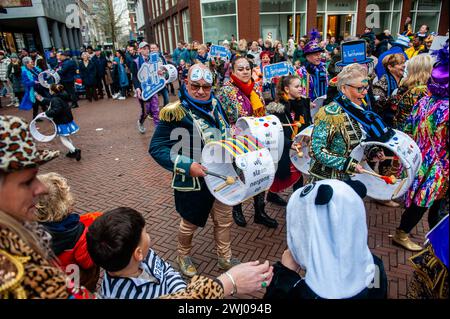Nijmegen, Niederlande. Februar 2024. Eine Musikband wird in bunten Kostümen vorgeführt. In Nijmegen, Niederlande, besteht die Karnevalsparade aus einem Wagen, der von einem Elektrofahrzeug mit den Prinzen und Prinzessinnen des Jahres gezogen wird. Der Rest der Parade besteht aus Personen, die in bunten Kostümen und Musikbands gekleidet sind. Die Hauptattraktion jedes Jahr ist das Kostüm, das der Bürgermeister der Stadt Huber Bruls trägt, dieses Jahr war das Thema Flower Power. Quelle: SOPA Images Limited/Alamy Live News Stockfoto
