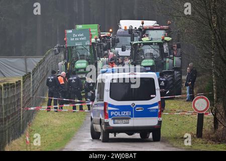 12. Februar 2024, Niedersachsen, Unterlüß: Demonstrierende Bauern blockieren eine Zufahrt zum Rüstungsunternehmen Rheinmetall. Bundeskanzler Scholz (SPD) wird an einem symbolischen Spatenstich zum Baubeginn einer neuen Munitionsfabrik Rheinmetall teilnehmen. Die Munitionsfabrik wird Artilleriemunition, Sprengstoff und Raketenartillerie herstellen. Foto: Philipp Schulze/dpa Stockfoto