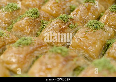 Traditionelles türkisches Dessert, Baklava, dekoriert mit zerstoßenen Pistazien, abstraktem Essenshintergrund Stockfoto