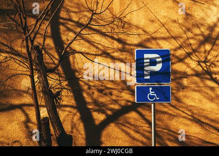 Barrierefreies Parkschild für behinderte Personen vor der leuchtend gelben Wand Stockfoto