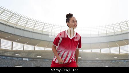 Bild einer birassischen Fußballspielerin über dem Stadion Stockfoto