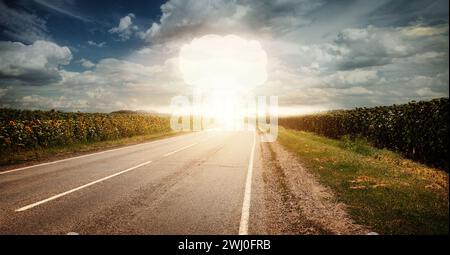 Nukleare Explosion im Freien mit blauer Himmelswolke und Sonnenblumenfeld. Gefahren der Kernenergie Stockfoto