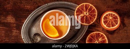 Orangentee mit frischen und getrockneten Orangen Panorama, eine Tasse auf einem Vintage-Tablett Stockfoto