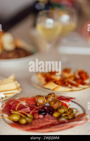 Zwei Gläser kühlen Champagner und Teller mit verschiedenen Snacks auf einem Tisch Stockfoto