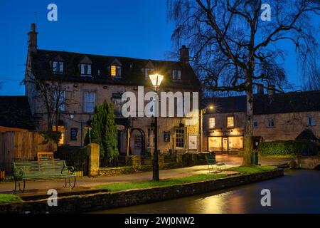 Old Manse Hotel und die Bäckerei am Wasser bei Sonnenaufgang. Bourton on the Water, Cotswolds, Gloucestershire, England Stockfoto