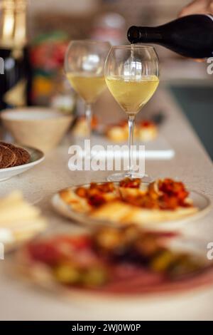 Zwei Gläser kühlen Champagner und Teller mit verschiedenen Snacks auf einem Tisch Stockfoto