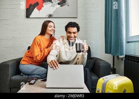 Ich war sehr begeistert, dass das Paar auf der Couch mit einem Laptop saß und vielleicht einen Ausflug im Hostel Zimmer buchte Stockfoto