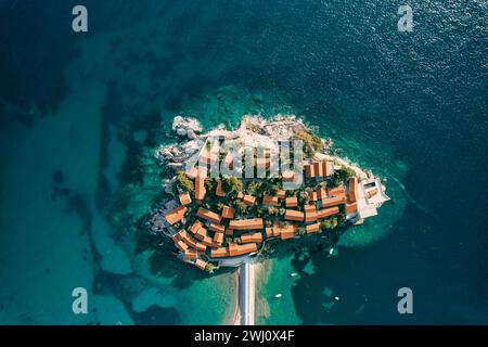 Rote Dächer von alten Häusern auf der felsigen Insel Sveti Stefan in der Bucht von Kotor. Montenegro. Draufsicht Stockfoto