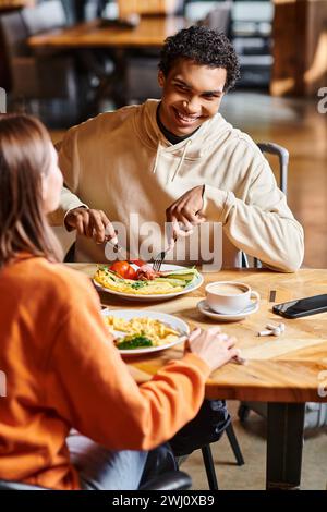Glückliches Paar teilt einen ruhigen Moment zusammen, während sie ein warmes Mittagessen im gemütlichen Café genießen Stockfoto