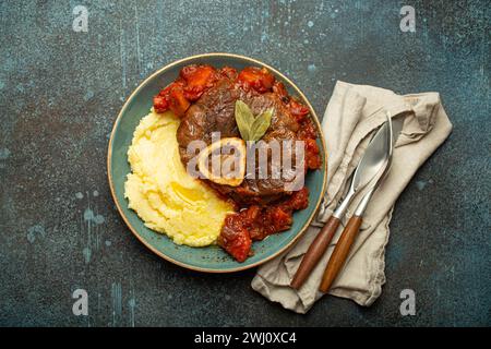 Traditionelles italienisches Gericht Ossobuco ganz Milanese mit geschnittenem Kalbsfleisch mit Tomatensoße serviert mit Maispolent Stockfoto