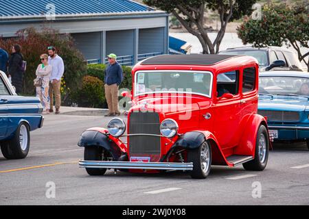 Klassischer hellroter Ford Tudor Modell B Hot Rod von 1932, der auf einer Straßenautoausstellung während der Morro Bay Autoausstellung in Kalifornien, USA, fährt Stockfoto