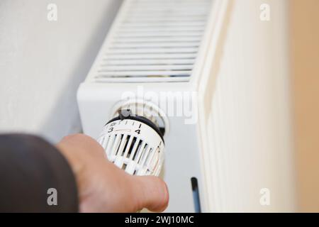 Hand mit Kühler. Handregulierung Nahaufnahme des Heizthermostats mit Kühler in Deutschland Stockfoto