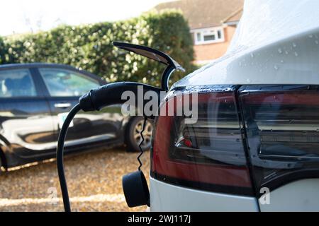 Elektrofahrzeug Tesla lädt zu Hause auf Stockfoto