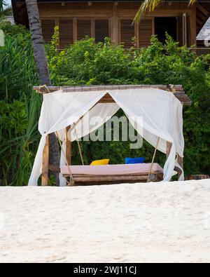 Weißes Stranddach bei Sonnenuntergang. Luxuriöse Strandzelte im luxuriösen Strandresort. Sommer Strandkonzept, unbeschwert, Erholung am Meer, Niemand am Strand. Garten o Stockfoto