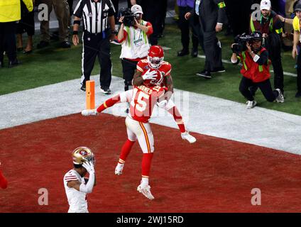 Las Vegas Nevada, USA. Februar 2024. Der Quarterback der Kansas City Chiefs PATRICK MAHOMES (15), nachdem er den siegreichen Touchdown auf den Wide Receiver MECOLE HARDMAN JR geworfen hatte. (12) gibt ihm eine große Siegesumarmung, als der SF-Verteidiger seinen Helm in der Niederlage abhebt. Ende eines ersten Overtime Super Bowl, seit neue OT-Regeln eingeführt wurden. Das NFL Super Bowl 58 LVIII Fußballspiel zwischen den San Francisco 49ers und den Kansas City Chiefs endet mit 25:22 gegen die SF 49ers. Quelle: csm/Alamy Live News Stockfoto