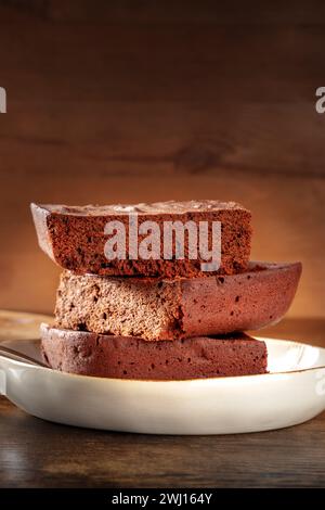 Schokoladenbrownie, einfacher Kaffeekuchen, ein Seitenblick auf einem dunklen rustikalen Holzhintergrund mit einem Platz für Text Stockfoto