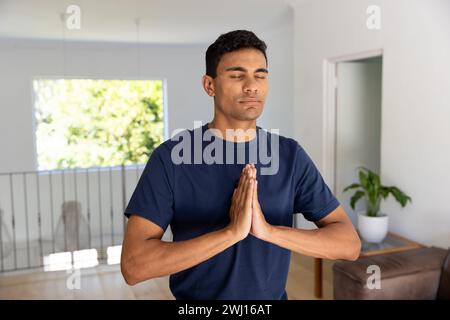 Birassischer Mann, der Yoga macht und zu Hause meditiert Stockfoto