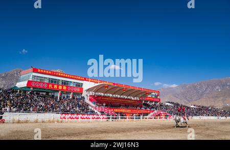 Lhasa. Februar 2024. Dieses Foto, das am 12. Februar 2024 aufgenommen wurde, zeigt eine Reitshow in Lhasa, der Autonomen Region Xizang im Südwesten Chinas. Das Reitteam der Autonomen Region Xizang im Südwesten Chinas veranstaltete am Montag, dem dritten Tag des tibetischen Neujahrs, eine aufregende Show traditioneller Pferderennen in seiner Hauptstadt Lhasa. Die Fahrer waren in bunten tibetischen Kleidern gekleidet und galoppierten anmutig um die Rennbahn in den nördlichen Vororten von Lhasa. Quelle: Sun Fei/Xinhua/Alamy Live News Stockfoto