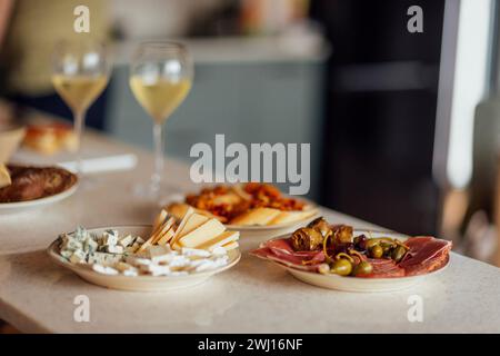 Zwei Gläser kühlen Champagner und Teller mit verschiedenen Snacks auf einem Tisch Stockfoto