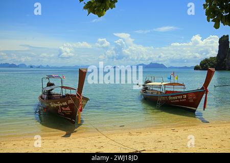 Insel Koh Pak Bia, Thailand, Juli 2017. Zwei traditionelle Langboot-Boote parken am tropischen Strand. Stockfoto