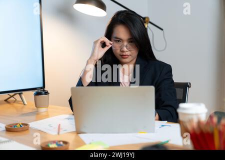 Junge Frau, die lange Zeit vom Sitzen und Arbeiten am Computer gestresst war Stockfoto