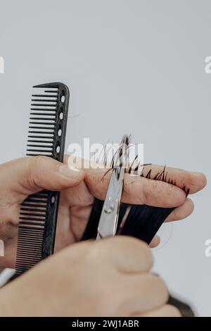 Extreme Nahaufnahme von Haaren, die mit einer Schere über einem Kamm geschnitten werden. Stockfoto