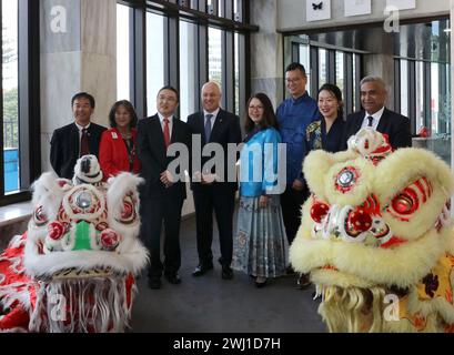 Wellington, Neuseeland. Februar 2024. Neuseeländischer Premierminister Christopher Luxon (4. L), chinesischer Botschafter in Neuseeland Wang Xiaolong (3. L) und andere Gäste posieren für ein Gruppenfoto mit Löwentanzkünstlern im neuseeländischen parlament in Wellington, Neuseeland, am 12. Februar 2024. Die Veranstaltung, die am Montag im neuseeländischen parlament stattfand, ist seit 2002 ein jährliches Treffen. Der neuseeländische Premierminister Christopher Luxon sagte zu der Feier, dass Neuseeland starke, vielfältige asiatische Gemeinschaften habe, die inspirierende Geschichten erzählen. Quelle: Meng Tao/Xinhua/Alamy Live News Stockfoto