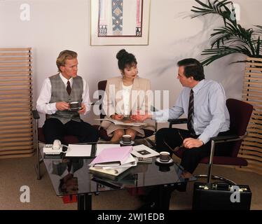 Geschäftsleute sitzen im Büro um einen Couchtisch. Stockfoto