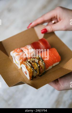 Sushi-Set auf Packbox in der Hand verschiedene japanische Sushi-Rollen Stockfoto