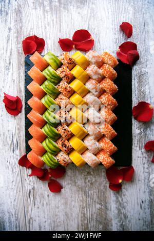 Verschiedene japanische Sushi-Rollen auf schwarzem Hintergrund. Asiatische oder japanische Küche Stockfoto