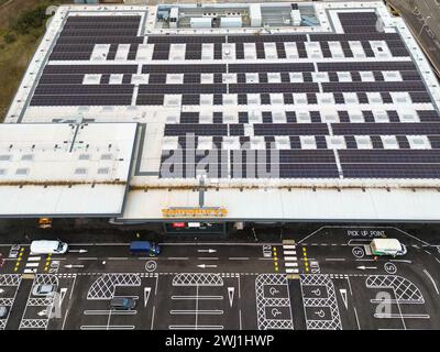 Pontyclun, Wales, Großbritannien - 11. Februar 2024: Blick von oben auf Solarpaneele auf dem Dach eines neuen Sainsbury's Supermarktes Stockfoto